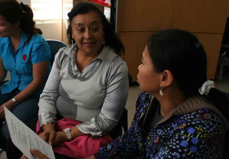 Two adult learners looking at each other and talking